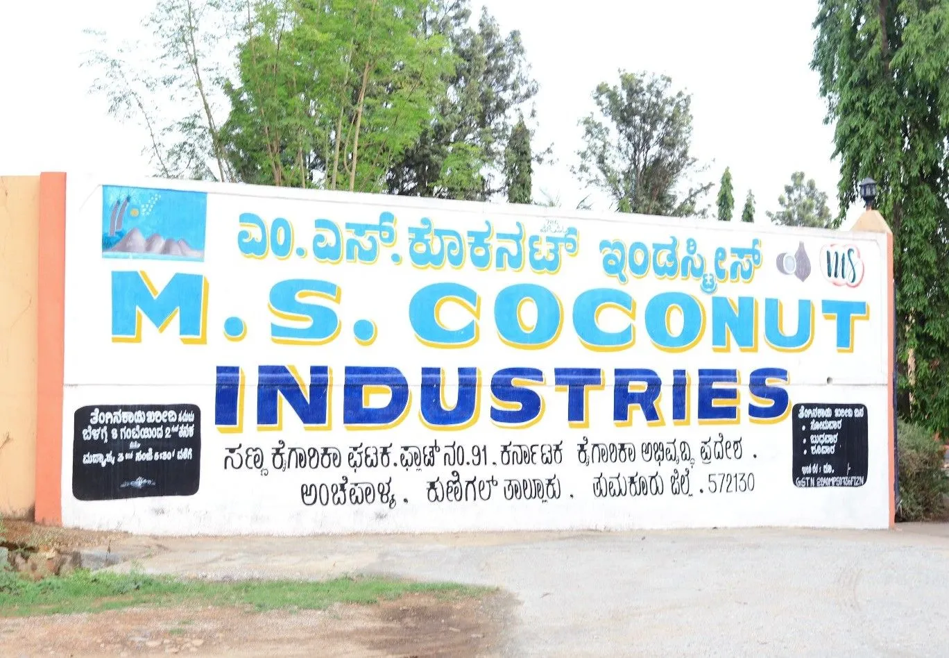 Painted entrance wall of M.S. Coconut Industries at KIADB Industrial Area, Kunigal, with coconut palms behind